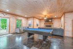 Basemsent Level Entertaiment Area Features Pool Table, Wet Bar, Flat Screen TV, Ample Seating, and Access to Lower Level Terrace